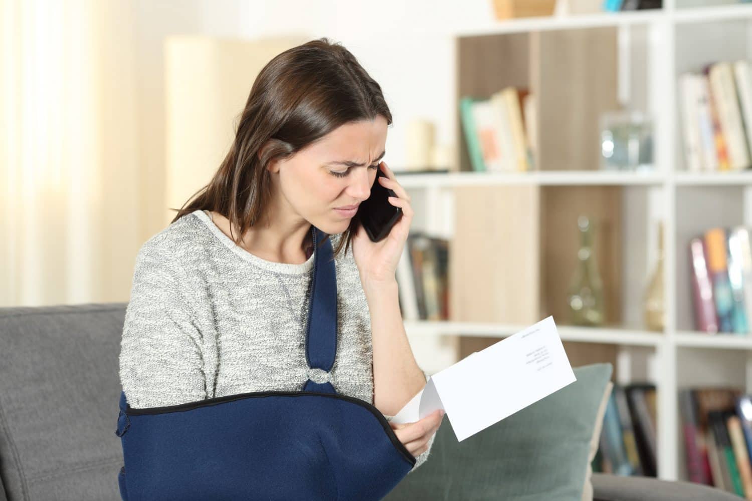 A woman with a broken arm calling her Cambridge, MA, personal injury lawyer for help