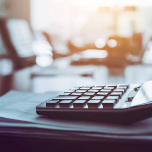 Close up calculator on business working desk, dark background.