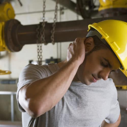 Worker wearing hardhat and experiencing neck pain