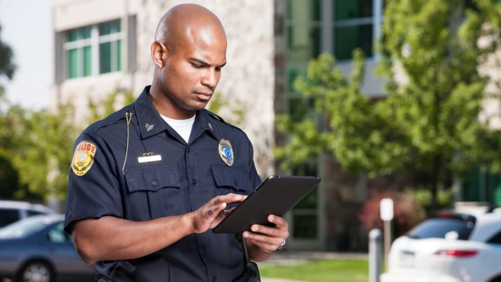 A police officer completes an accident report at the scene of a car accident.