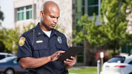 A police officer completes an accident report at the scene of a car accident.