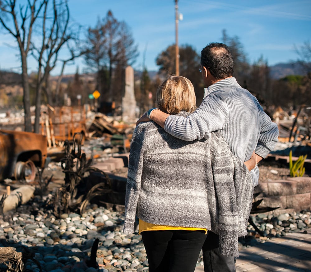 Homeowners in Boston, MA, looking at the damage to their property after a fire.