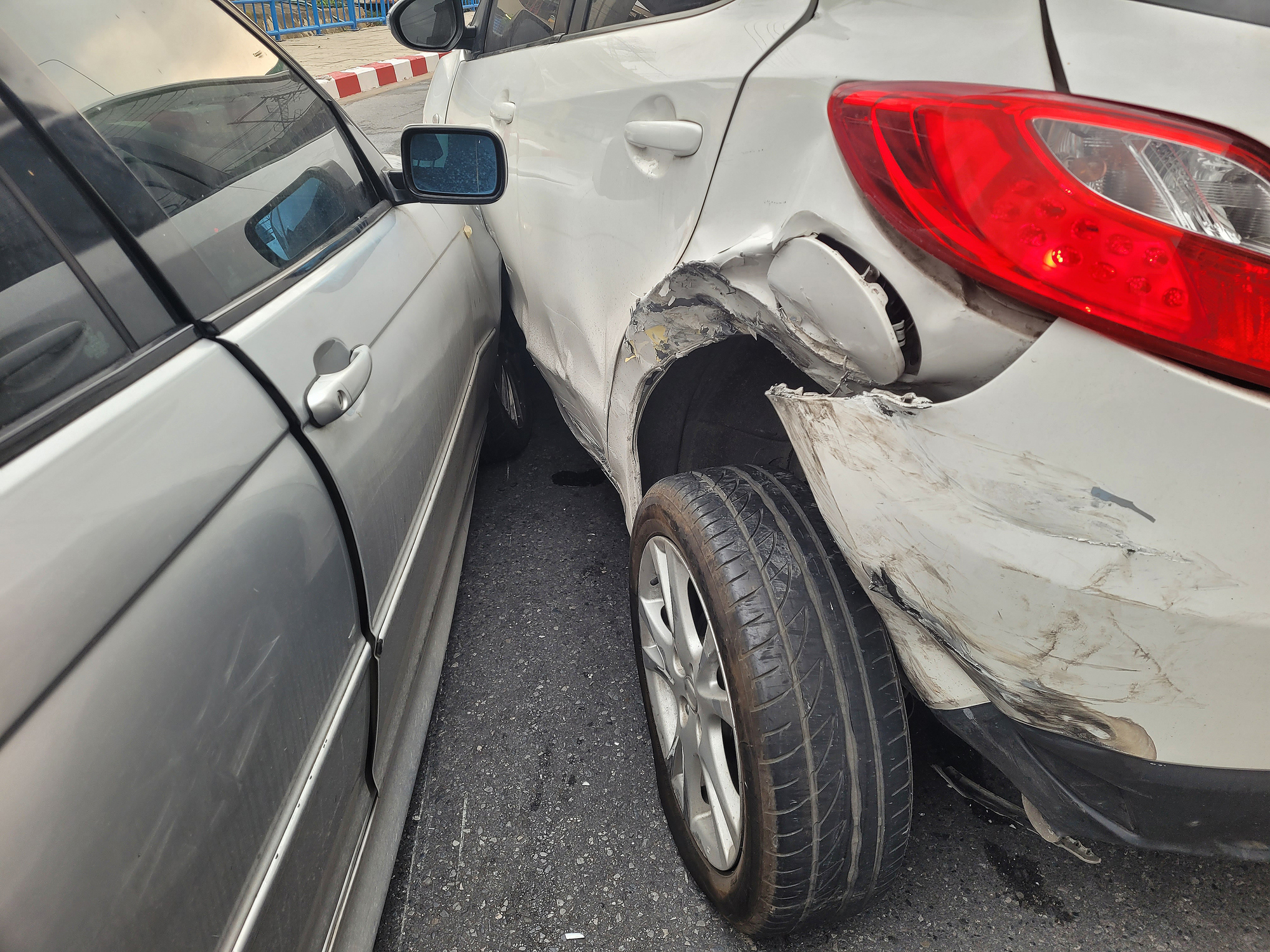 Two cars are shown after a collision on a city street.